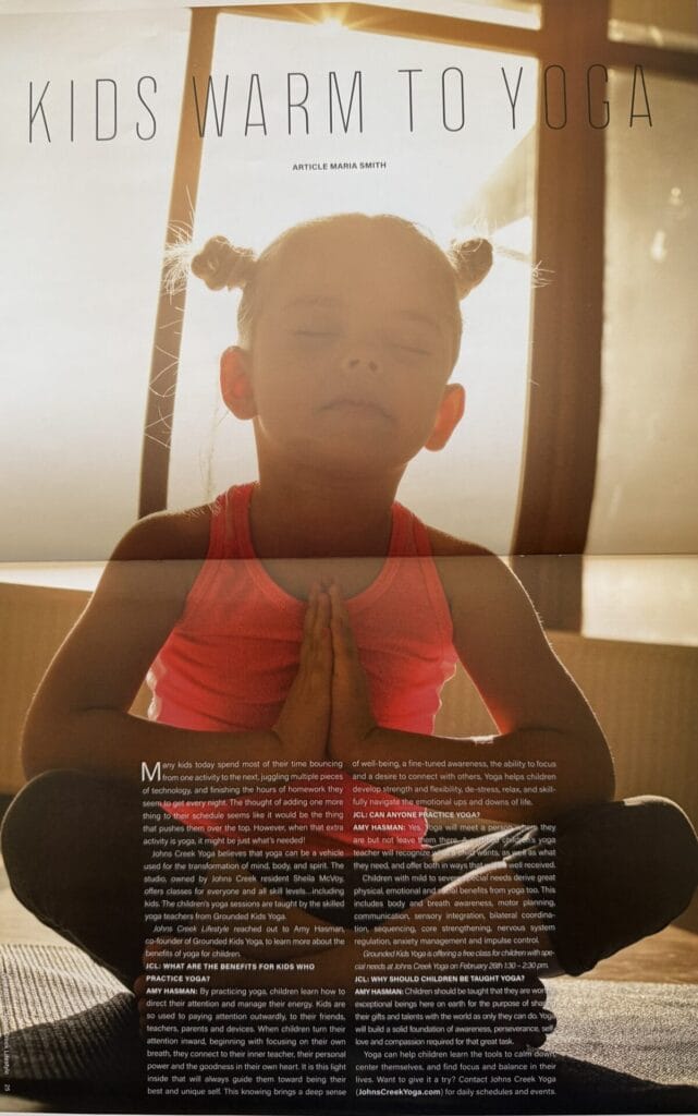 Child meditating in sunlight during a kids' yoga class.
