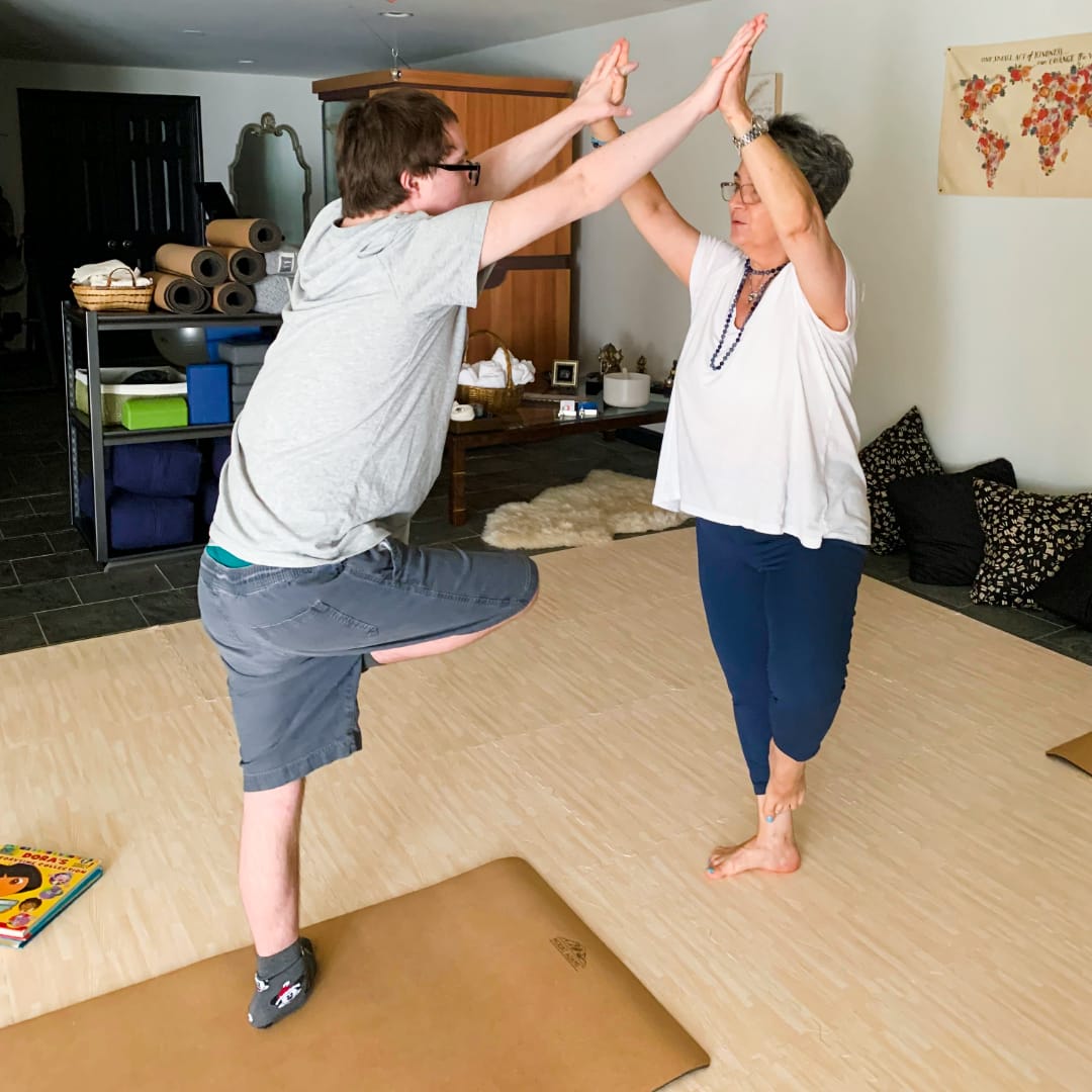 Jacob in a focused pose during a Grounded Kids Yoga class, showing calm concentration