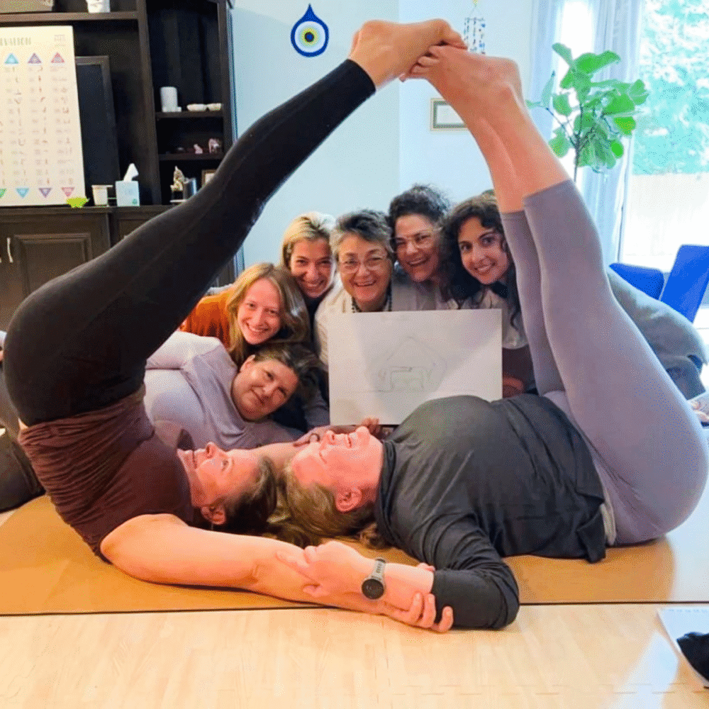 Kids yoga teacher training in progress, with adults practicing group poses in a supportive and fun classroom setting