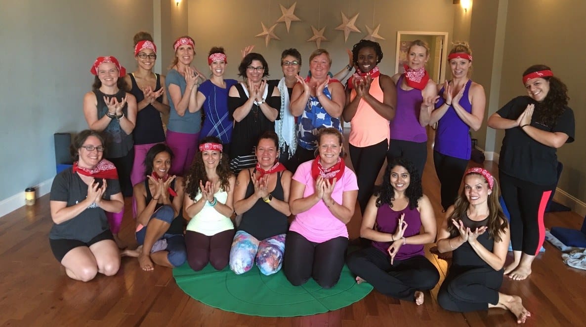A group of adults in red bandanas at the end of a Grounded Kids children’s yoga teacher training hosted at Johns Creek Yoga.