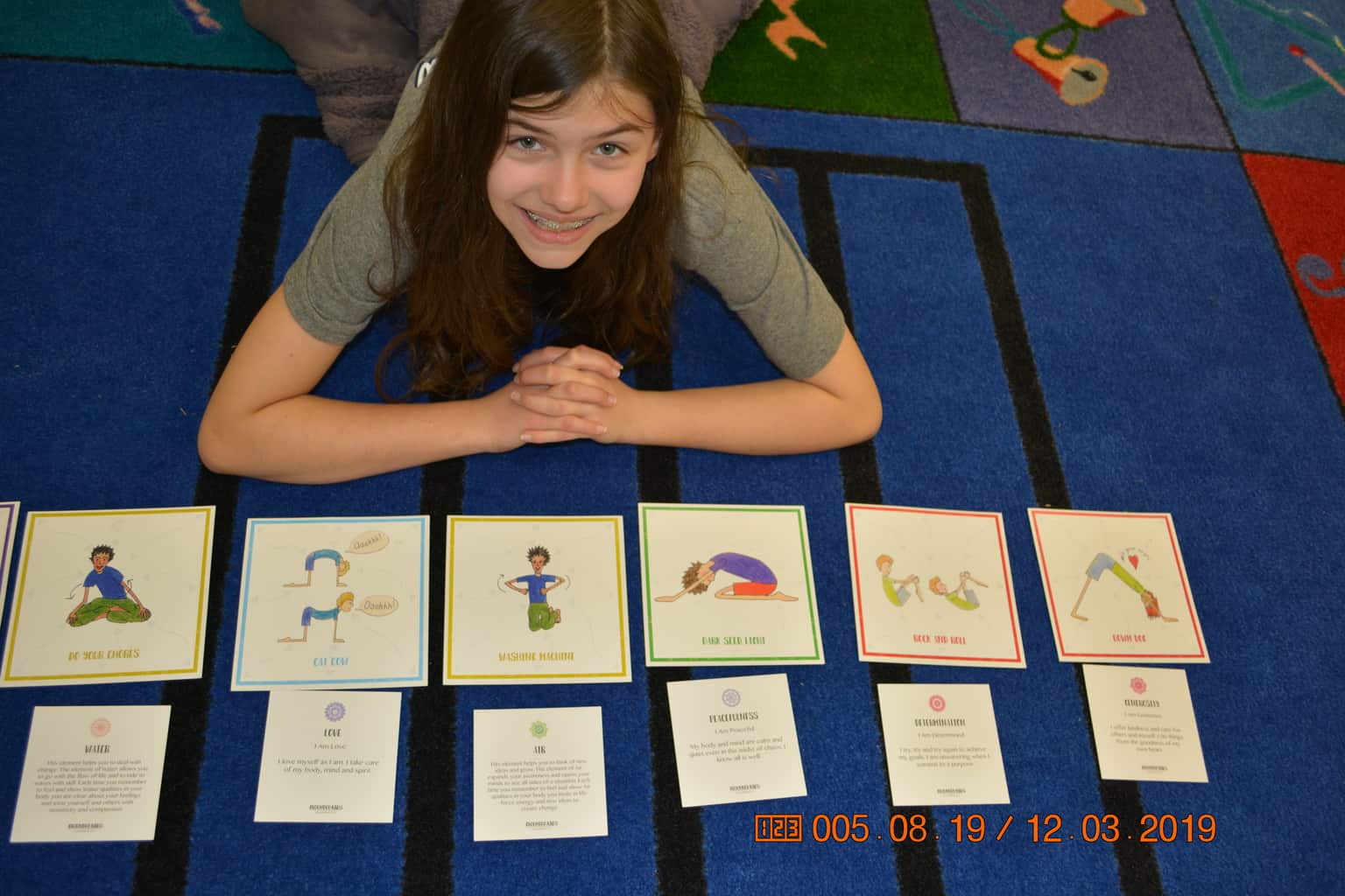 Student creating yoga pose sequence using elemental mantra cards in class